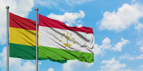 Bolivia and Tajikistan flag waving in the wind against white cloudy blue sky together. Diplomacy concept, international relations.