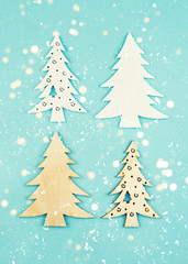 Wooden decorative Christmas trees on a blue background with sparkles. Hanging Christmas decorations.