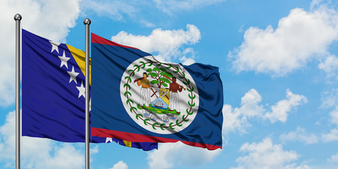 Bosnia Herzegovina and Belize flag waving in the wind against white cloudy blue sky together....