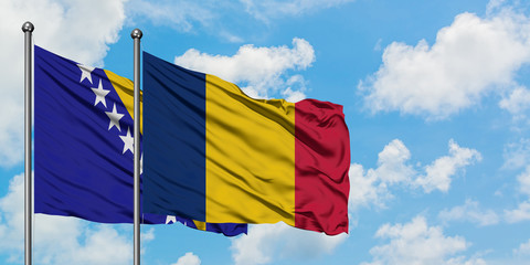 Bosnia Herzegovina and Chad flag waving in the wind against white cloudy blue sky together. Diplomacy concept, international relations.