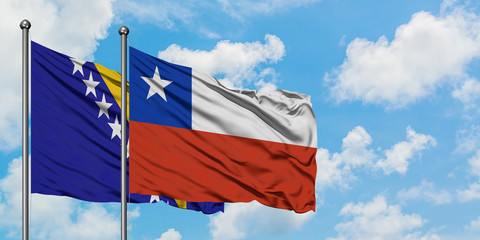 Bosnia Herzegovina and Chile flag waving in the wind against white cloudy blue sky together. Diplomacy concept, international relations.