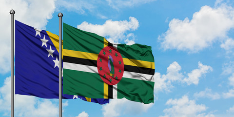 Bosnia Herzegovina and Dominica flag waving in the wind against white cloudy blue sky together. Diplomacy concept, international relations.