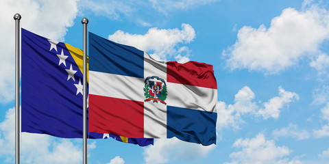 Bosnia Herzegovina and Dominican Republic flag waving in the wind against white cloudy blue sky...