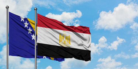 Bosnia Herzegovina and Egypt flag waving in the wind against white cloudy blue sky together. Diplomacy concept, international relations.