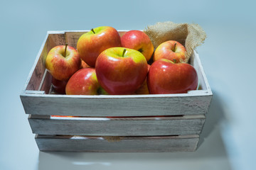 wooden box full of apples on a white background.