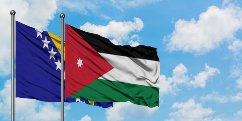 Bosnia Herzegovina and Jordan flag waving in the wind against white cloudy blue sky together. Diplomacy concept, international relations.