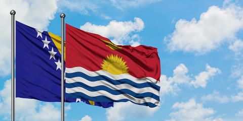 Bosnia Herzegovina and Kiribati flag waving in the wind against white cloudy blue sky together. Diplomacy concept, international relations.
