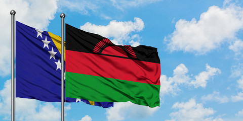 Bosnia Herzegovina and Malawi flag waving in the wind against white cloudy blue sky together. Diplomacy concept, international relations.