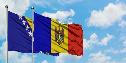 Bosnia Herzegovina and Moldova flag waving in the wind against white cloudy blue sky together....