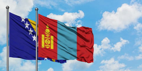 Bosnia Herzegovina and Mongolia flag waving in the wind against white cloudy blue sky together. Diplomacy concept, international relations.