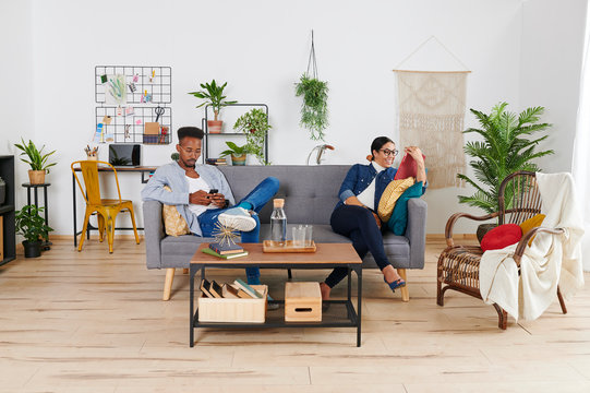 Multiethnic couple spending time together at living room