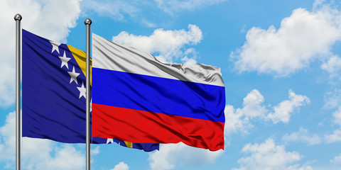 Bosnia Herzegovina and Russia flag waving in the wind against white cloudy blue sky together. Diplomacy concept, international relations.