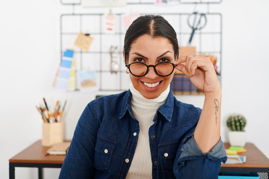Young smiling woman with hand on glasses