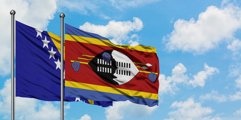 Bosnia Herzegovina and Swaziland flag waving in the wind against white cloudy blue sky together....