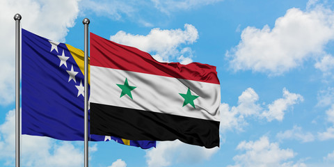 Bosnia Herzegovina and Syria flag waving in the wind against white cloudy blue sky together. Diplomacy concept, international relations.