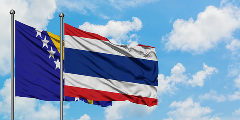 Bosnia Herzegovina and Thailand flag waving in the wind against white cloudy blue sky together. Diplomacy concept, international relations.