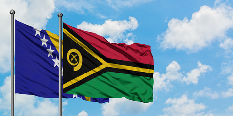 Bosnia Herzegovina and Vanuatu flag waving in the wind against white cloudy blue sky together. Diplomacy concept, international relations.