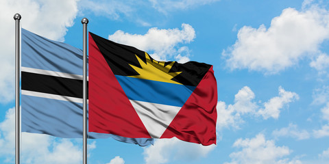 Botswana and Antigua and Barbuda flag waving in the wind against white cloudy blue sky together. Diplomacy concept, international relations.