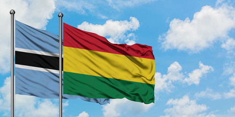 Botswana and Bolivia flag waving in the wind against white cloudy blue sky together. Diplomacy concept, international relations.