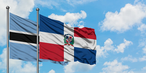 Botswana and Dominican Republic flag waving in the wind against white cloudy blue sky together. Diplomacy concept, international relations.
