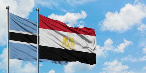 Botswana and Egypt flag waving in the wind against white cloudy blue sky together. Diplomacy concept, international relations.