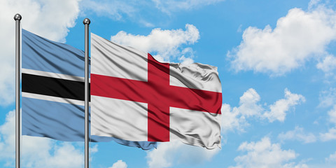 Botswana and England flag waving in the wind against white cloudy blue sky together. Diplomacy concept, international relations.
