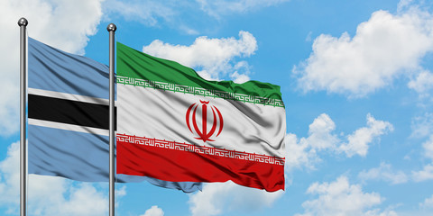 Botswana and Iran flag waving in the wind against white cloudy blue sky together. Diplomacy concept, international relations.