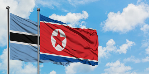 Botswana and North Korea flag waving in the wind against white cloudy blue sky together. Diplomacy concept, international relations.