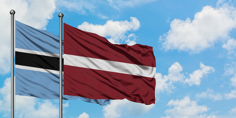 Botswana and Latvia flag waving in the wind against white cloudy blue sky together. Diplomacy concept, international relations.