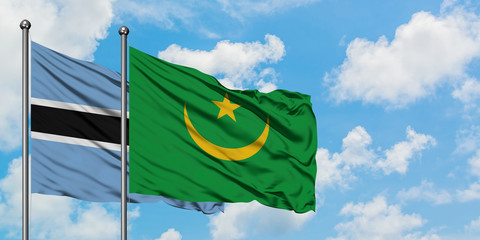 Botswana and Mauritania flag waving in the wind against white cloudy blue sky together. Diplomacy concept, international relations.