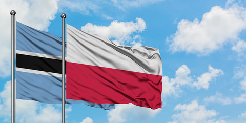 Botswana and Poland flag waving in the wind against white cloudy blue sky together. Diplomacy concept, international relations.