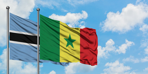 Botswana and Senegal flag waving in the wind against white cloudy blue sky together. Diplomacy concept, international relations.