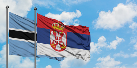 Botswana and Serbia flag waving in the wind against white cloudy blue sky together. Diplomacy concept, international relations.