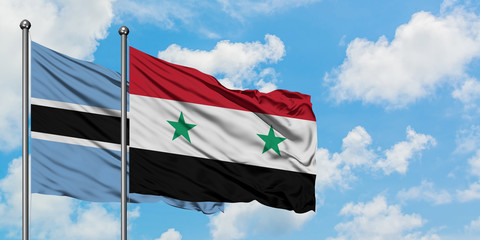 Botswana and Syria flag waving in the wind against white cloudy blue sky together. Diplomacy concept, international relations.