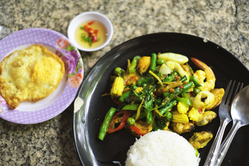 Fried stir spicy sea food with steamed rice and fried egg