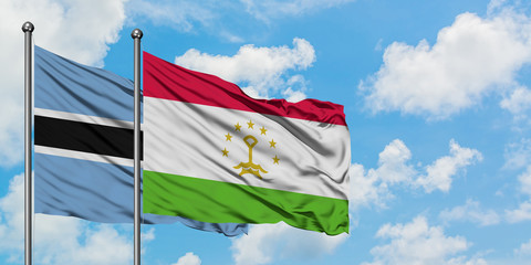 Botswana and Tajikistan flag waving in the wind against white cloudy blue sky together. Diplomacy concept, international relations.