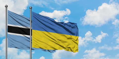 Botswana and Ukraine flag waving in the wind against white cloudy blue sky together. Diplomacy concept, international relations.