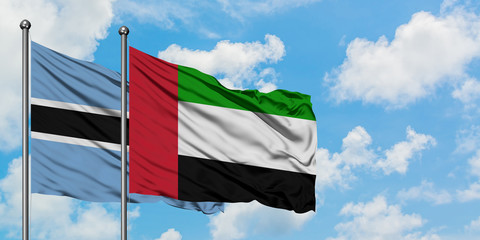 Botswana and United Arab Emirates flag waving in the wind against white cloudy blue sky together. Diplomacy concept, international relations.