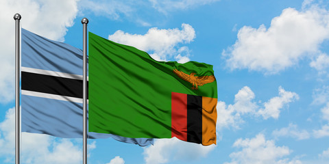 Botswana and Zambia flag waving in the wind against white cloudy blue sky together. Diplomacy concept, international relations.