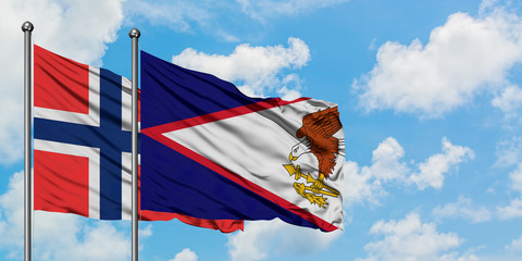 Bouvet Islands and American Samoa flag waving in the wind against white cloudy blue sky together....