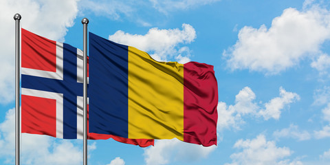 Bouvet Islands and Chad flag waving in the wind against white cloudy blue sky together. Diplomacy concept, international relations.