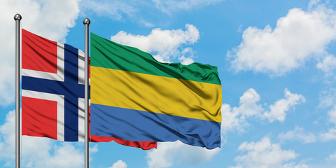 Bouvet Islands and Gabon flag waving in the wind against white cloudy blue sky together. Diplomacy concept, international relations.