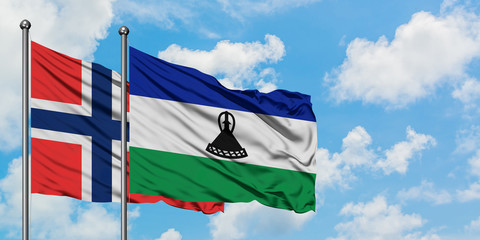 Bouvet Islands and Lesotho flag waving in the wind against white cloudy blue sky together. Diplomacy concept, international relations.