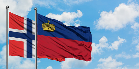 Bouvet Islands and Liechtenstein flag waving in the wind against white cloudy blue sky together. Diplomacy concept, international relations.