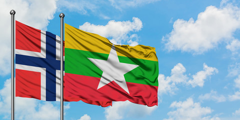 Bouvet Islands and Myanmar flag waving in the wind against white cloudy blue sky together. Diplomacy concept, international relations.