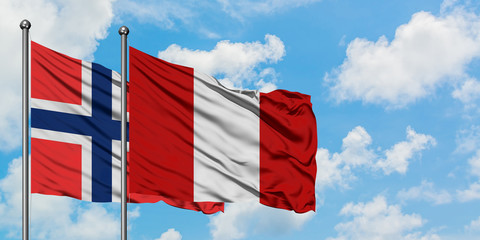 Bouvet Islands and Peru flag waving in the wind against white cloudy blue sky together. Diplomacy concept, international relations.