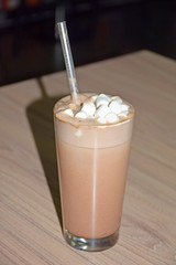 Glass cup with cocoa on a table in a restaurant. Photography of coffee drinks. Use in food, restaurant and other fields. 