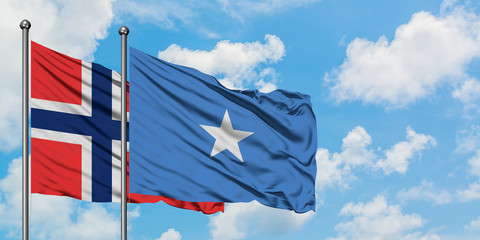 Bouvet Islands and Somalia flag waving in the wind against white cloudy blue sky together. Diplomacy concept, international relations.