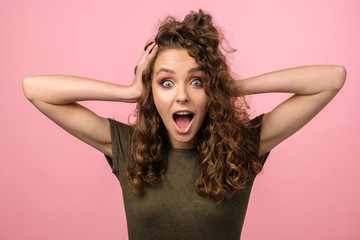 Attractive girl with curly hair on pink