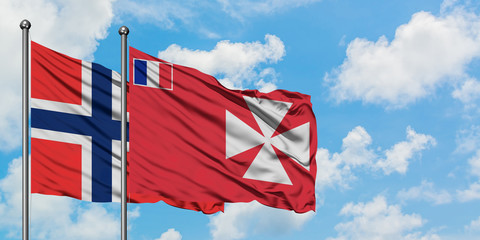 Bouvet Islands and Wallis And Futuna flag waving in the wind against white cloudy blue sky...